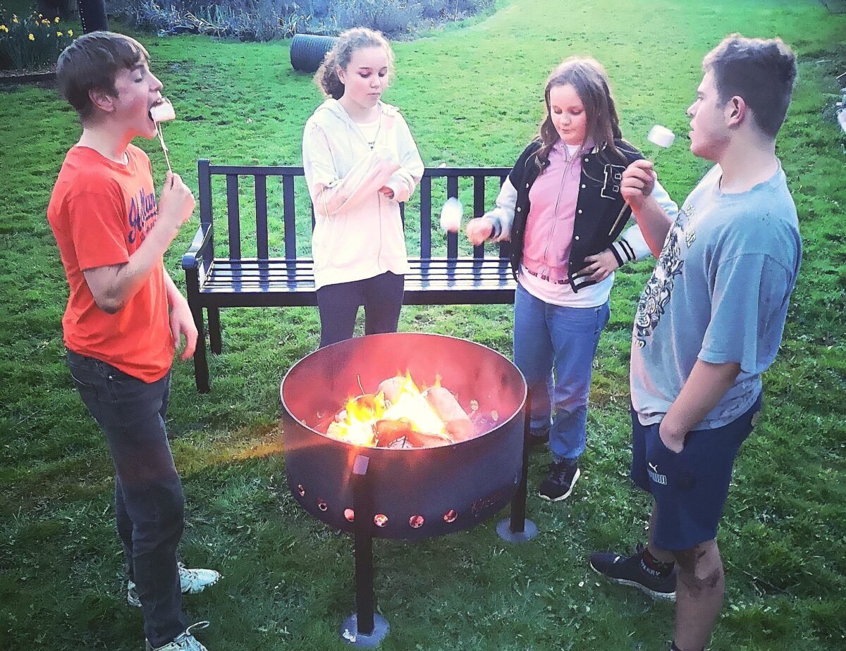 Children toasting marshmallows over firepit